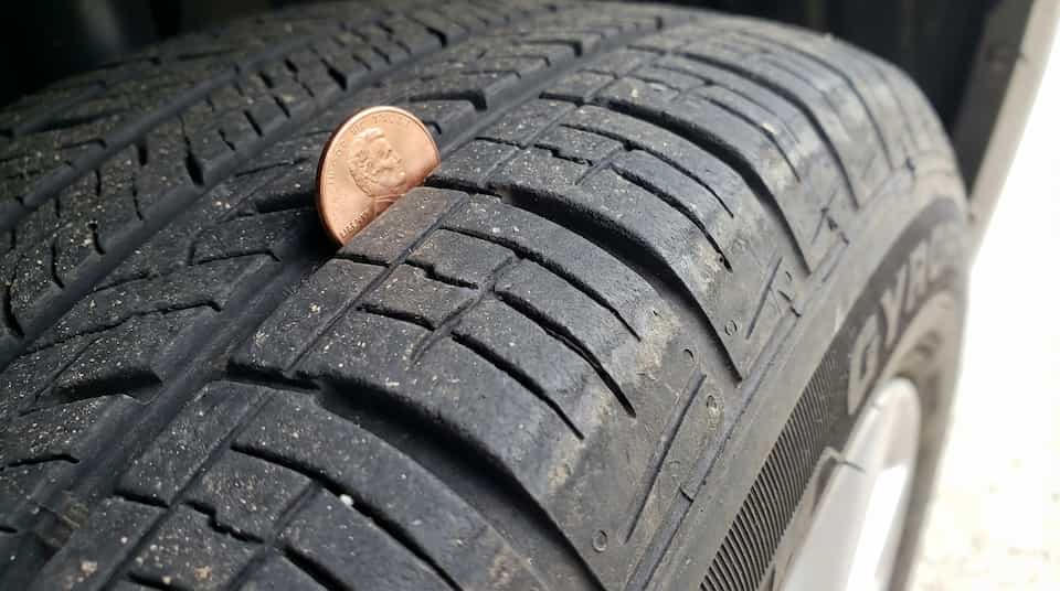 Penny inserted in a tire groove to check remaining tread